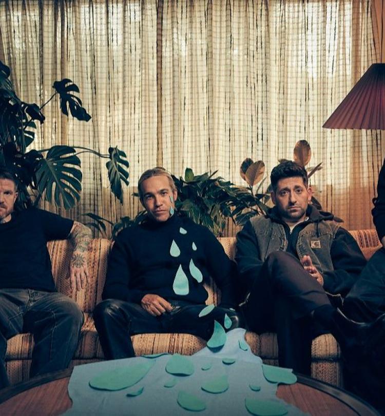 A photo of Fall Out Boy Sitting On A Couch